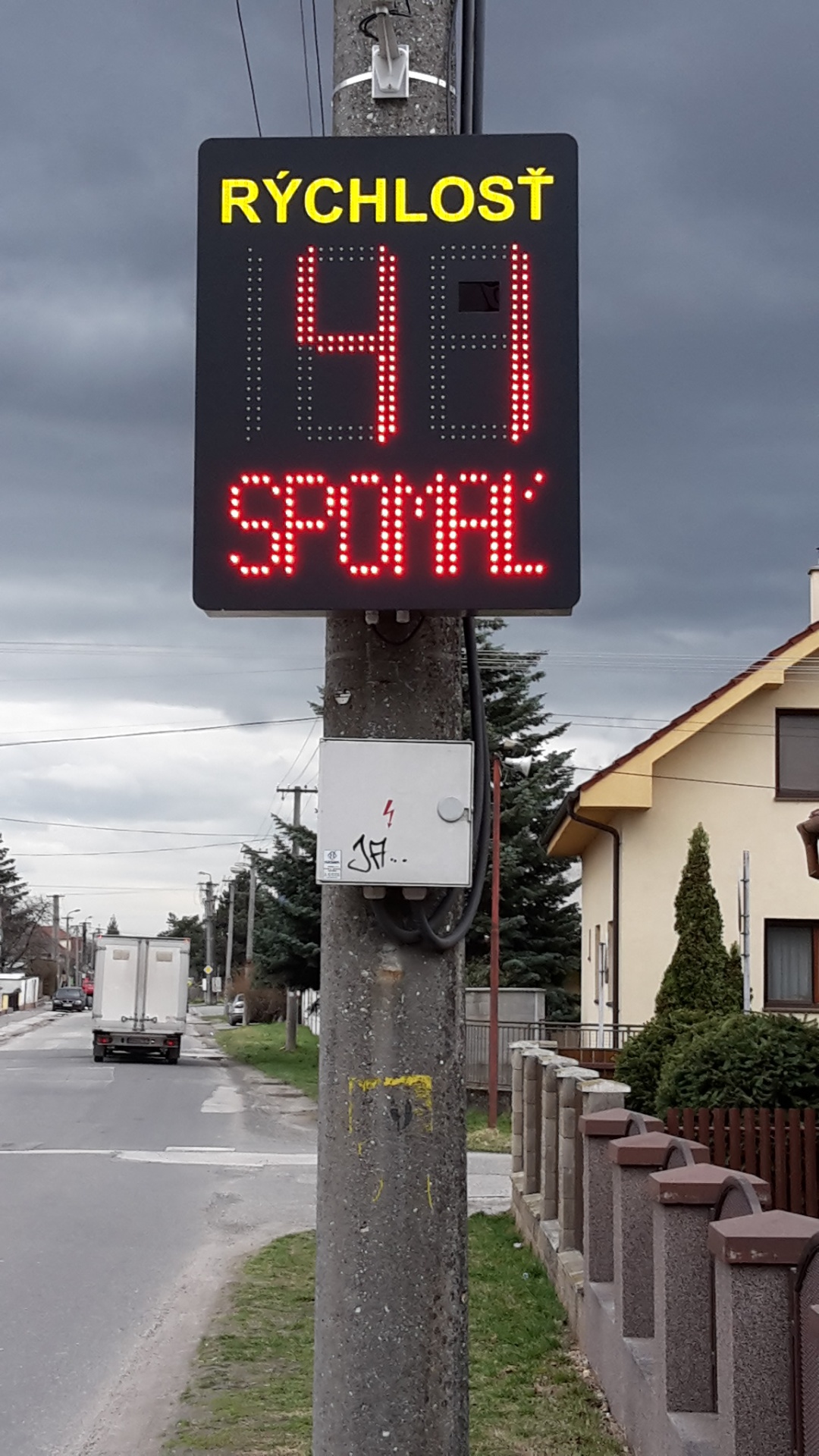 Merač rýchlosti BELLIMPEX s LED nápisom SPOMAĽ osadený v obci.